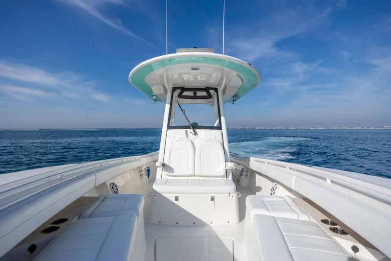 Slide: The Image of 2022 Regulator 31 boat cruising on open water under clear blue sky. - 12