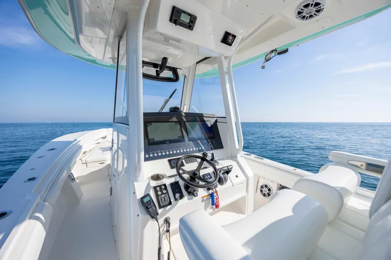 Slide: The Image of 2022 Regulator 31 boat cockpit with modern controls, steering wheel, and ocean view. - 17