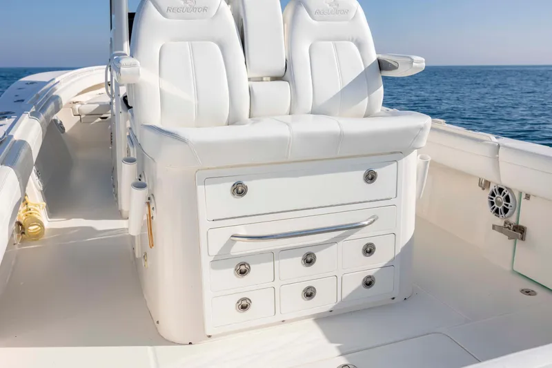 Slide: The Image of 2022 Regulator 31 boat interior with white seating and storage drawers. - 25