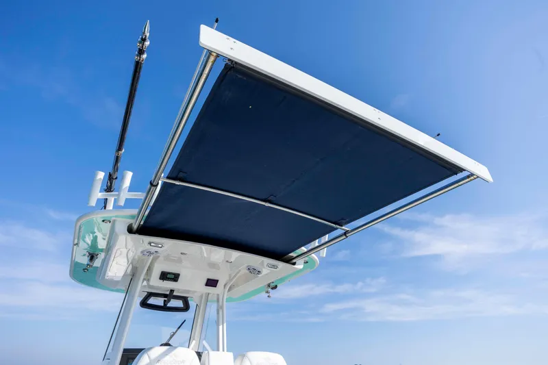 Slide: The Image of 2022 Regulator 31 boat with extended sunshade against clear blue sky. - 32