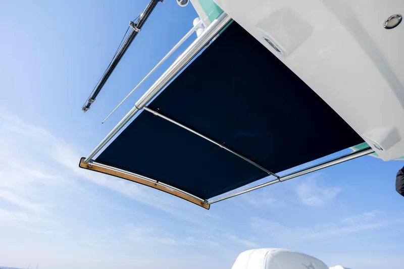 Slide: The Image of 2022 Regulator 31 boat with extended sunshade against clear blue sky. - 33