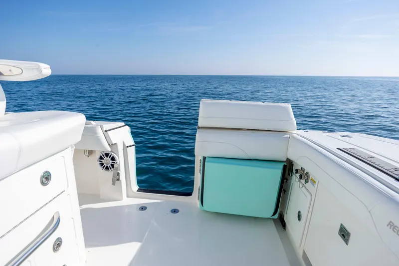 Slide: The Image of 2022 Regulator 31 boat interior with ocean view, featuring white seating and storage compartments. - 37