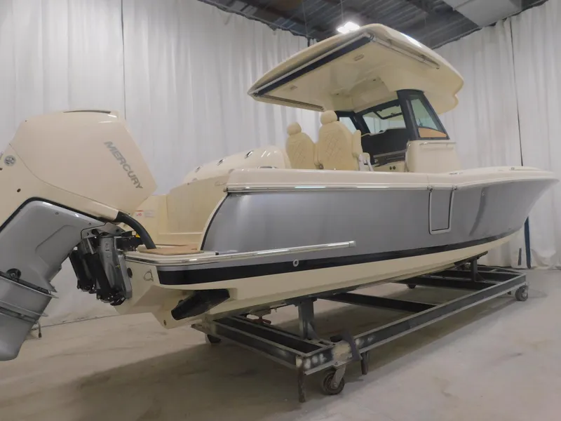 Slide: The Image of 2023 Chris-Craft Catalina 30 boat in indoor storage, surrounded by other covered boats. - 2