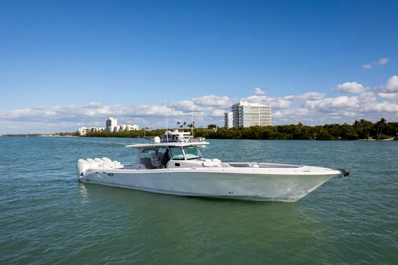 Slide: The Image of 2024 HCB 53 Sueños boat cruising on a sunny day near coastal buildings. - 4