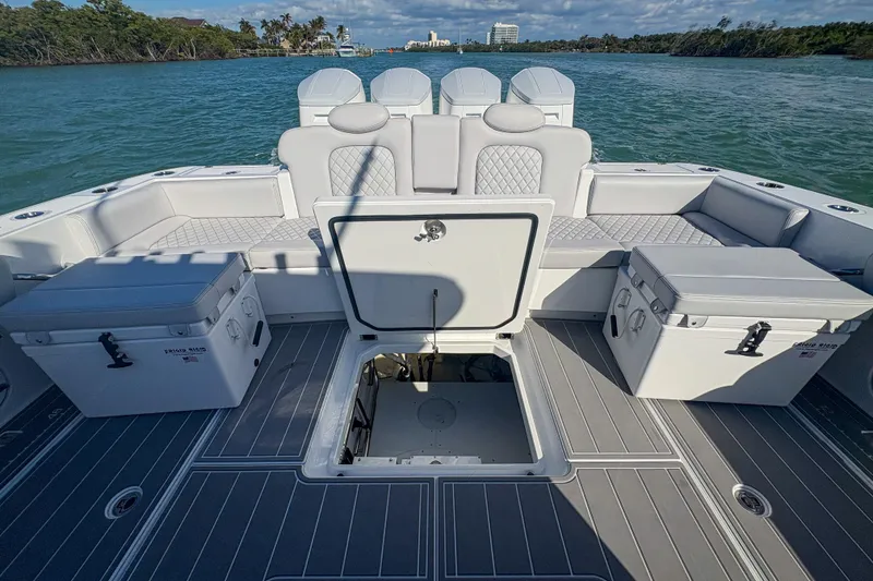 Slide: The Image of 2024 HCB 53 Sueños boat interior with open hatch, seating, and coolers on a sunny day. - 48