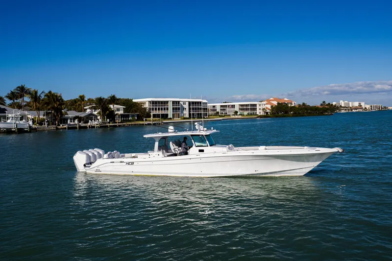 Slide: The Image of 2024 HCB 53 Sueños luxury boat cruising on a sunny waterfront. - 7