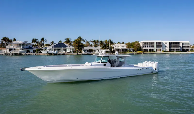 Slide: The Image of 2024 HCB 53' Suenos boat cruising on a sunny waterfront. - 11