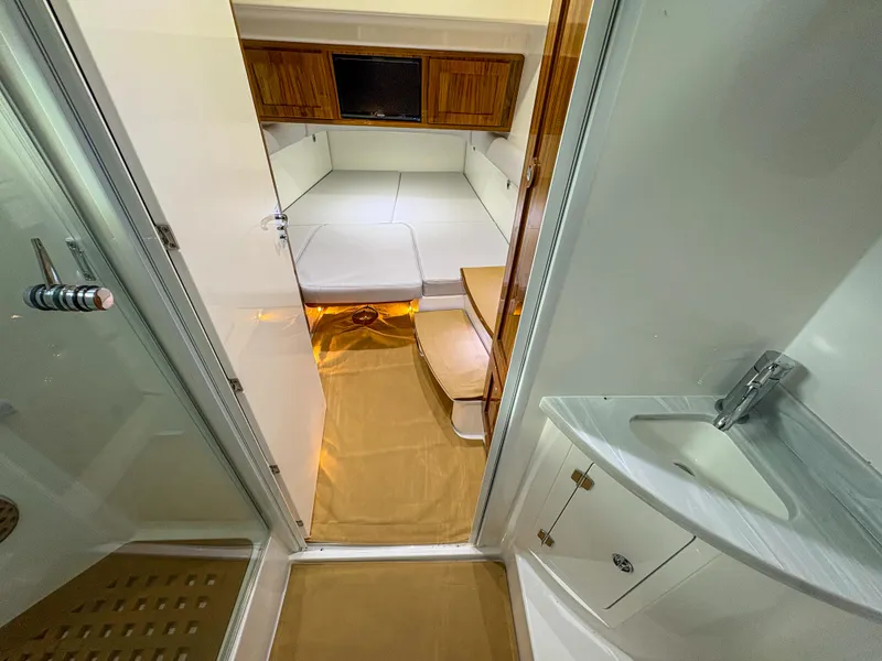 Slide: The Image of 2024 HCB 53' Suenos cabin interior with bed, sink, and wooden accents. - 12
