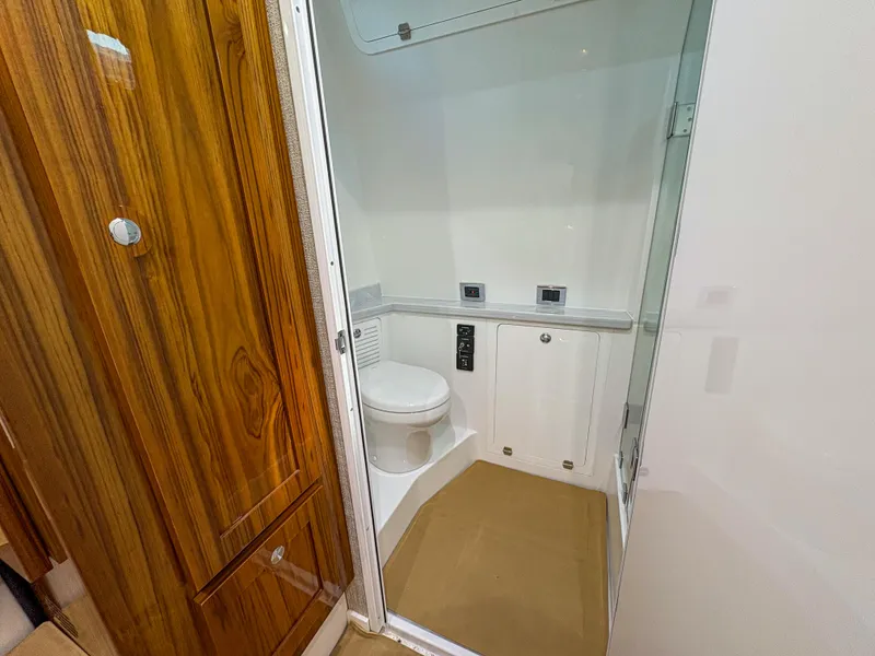 Slide: The Image of 2024 HCB 53' Suenos boat bathroom with wooden door and modern fixtures. - 18