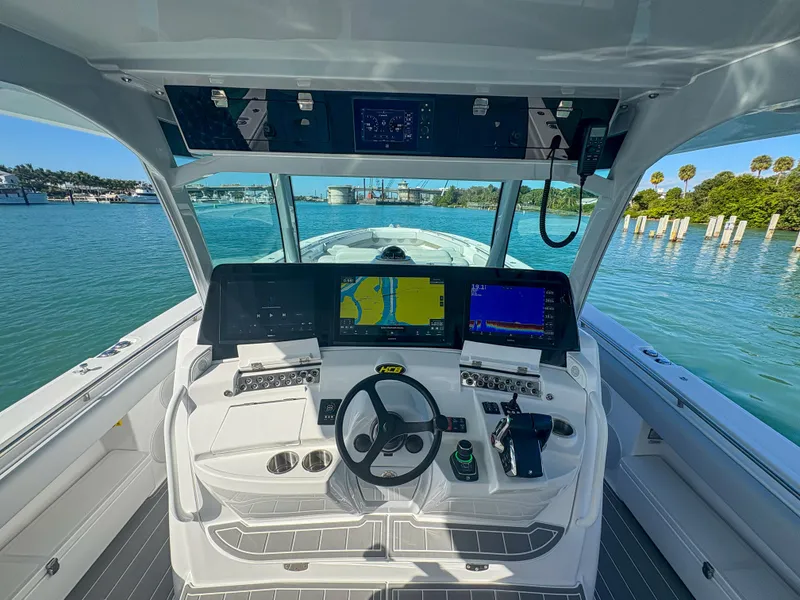 Slide: The Image of 2024 HCB 53' Suenos boat cockpit with advanced navigation systems on a sunny day. - 24