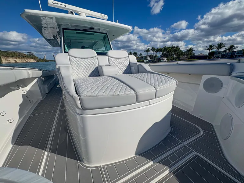 Slide: The Image of 2024 HCB 53' Suenos luxury boat with plush seating and sleek design under a blue sky. - 32