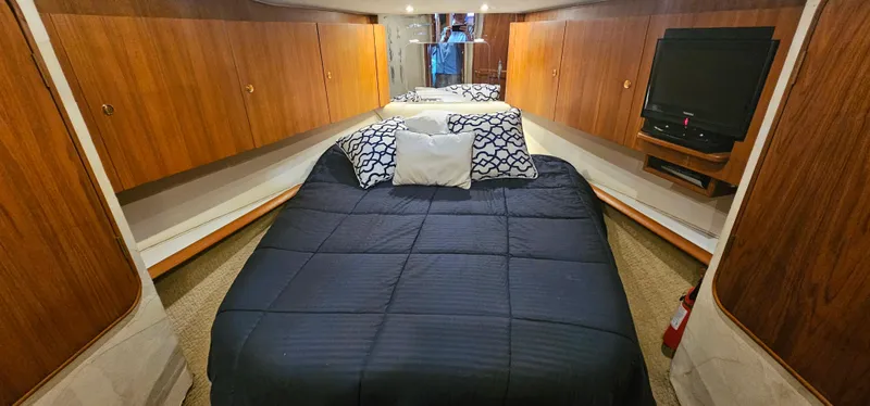 Slide: The Image of 1997 Ocean Yachts 48 Super Sport bedroom with double bed and wooden cabinets. - 35