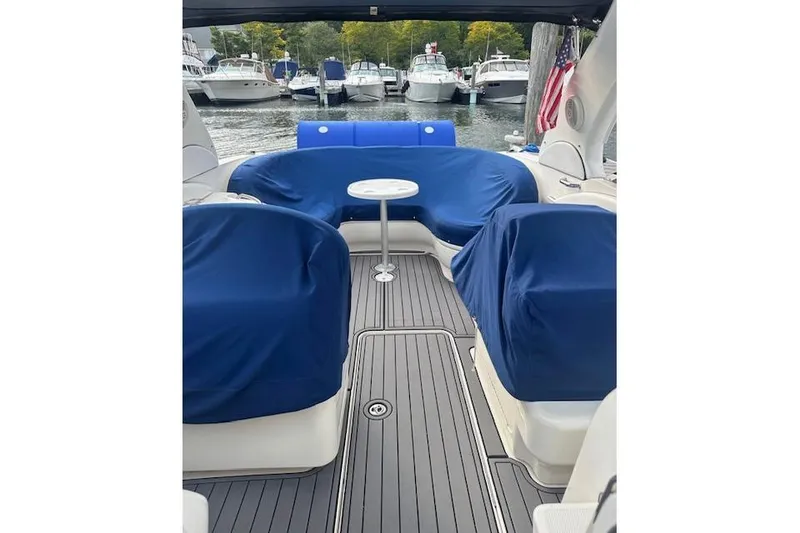 Slide: The Image of 2007 Sea Ray 290 Sun Sport interior with blue covers, docked among other boats. - 8