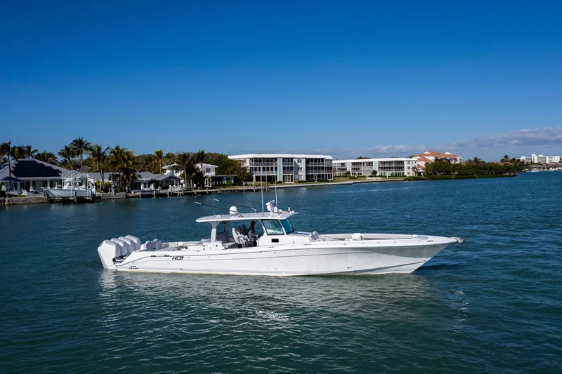 Slide: The Image of 2024 HCB 53' Suenos luxury boat cruising on a sunny waterfront. - 1