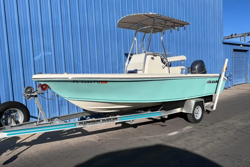 The Image of 2015 Release 190RX boat on trailer, parked by blue building. - 1