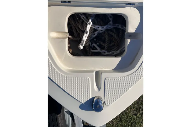 Slide: The Image of Anchor storage compartment on 2015 Release 190RX boat, featuring rope and chain. - 19