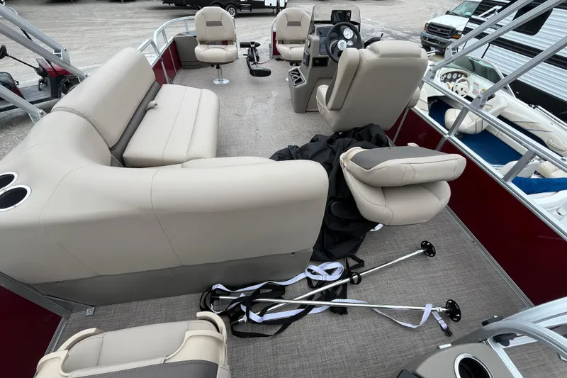 Slide: The Image of 2025 Sun Tracker Bass Buggy 18 DLX pontoon boat interior with beige seating and steering console. - 13