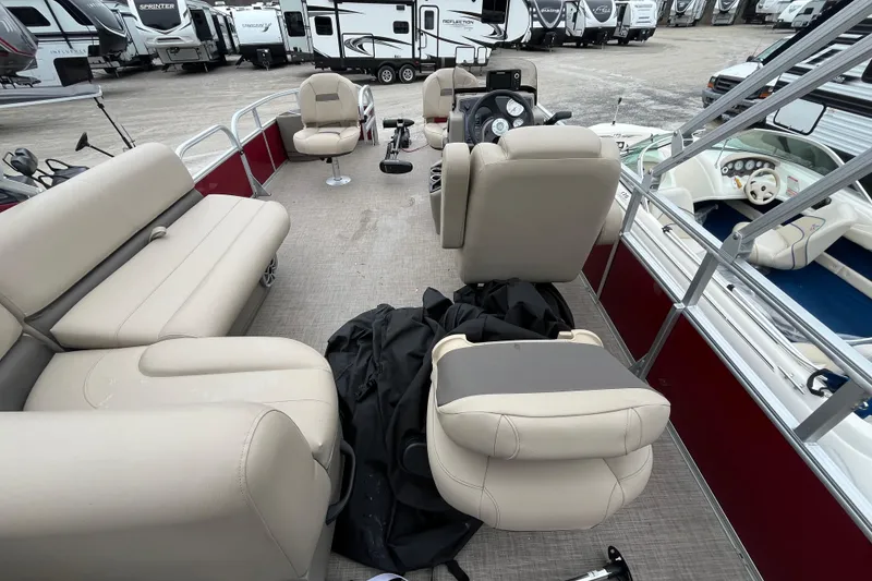 Slide: The Image of 2025 Sun Tracker Bass Buggy 18 DLX pontoon boat interior with beige seating and steering console. - 16