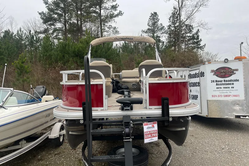 Slide: The Image of 2025 Sun Tracker Bass Buggy 18 DLX pontoon boat displayed outdoors. - 17