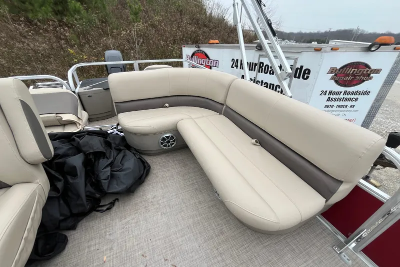 Slide: The Image of 2025 Sun Tracker Bass Buggy 18 DLX pontoon boat with beige seating and roadside assistance trailer. - 8