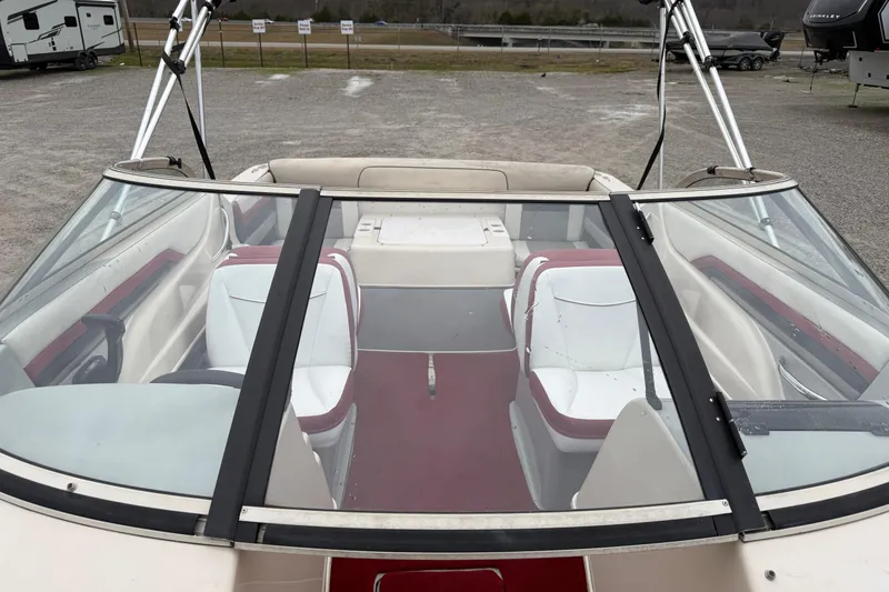 Slide: The Image of 1995 Donzi 212 Medallion boat interior with white and red seating, parked outdoors. - 16