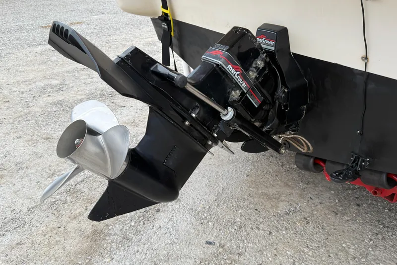 Slide: The Image of 1995 Donzi 212 Medallion boat with MerCruiser outdrive and propeller, parked on gravel. - 17