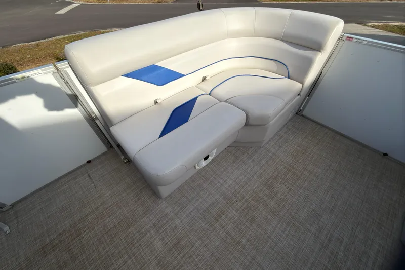 Slide: The Image of 2021 SunCatcher Select 20C boat interior with white and blue cushioned seating. - 18
