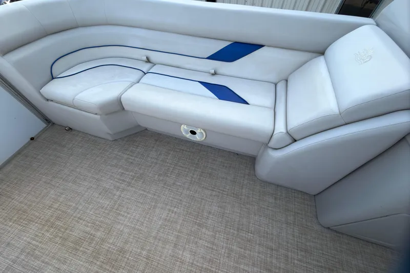 Slide: The Image of 2021 SunCatcher Select 20C boat interior with white and blue cushioned seating. - 19