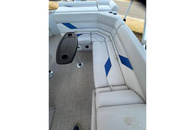 Slide: The Image of 2021 SunCatcher Select 20C boat interior with white and blue seating, and a black table. - 7