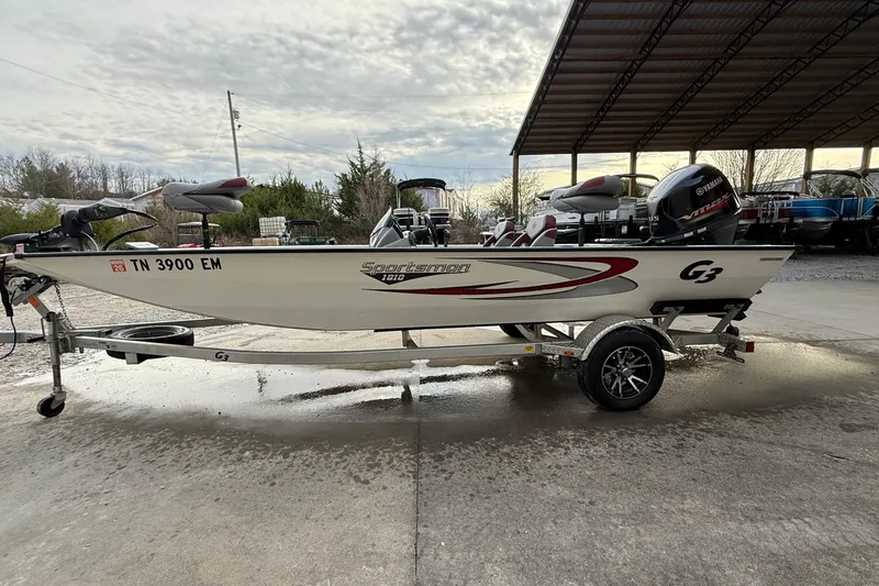 Slide: The Image of 2021 G3 Sportsman 1810 boat on trailer, parked outdoors under cloudy sky. - 12