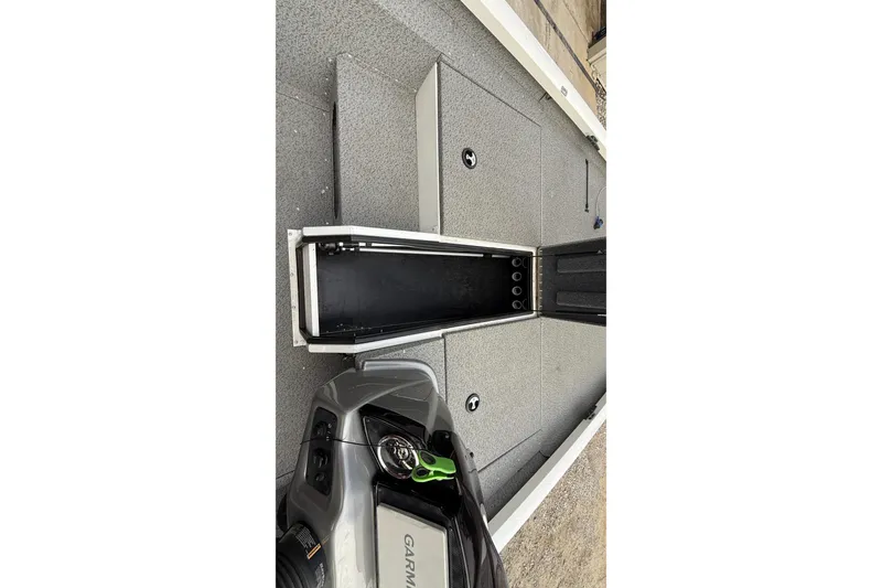 Slide: The Image of 2021 G3 Sportsman 1810 boat interior with open storage compartments and Garmin equipment. - 18