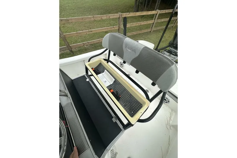 Slide: The Image of 2022 BlackJack 256 Bay boat seat with storage compartment, outdoor setting. - 12