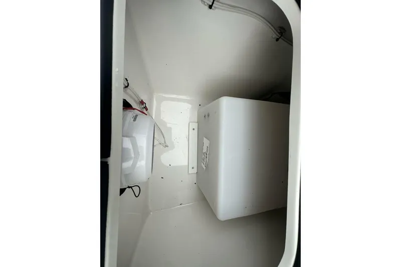Slide: The Image of Interior compartment of 2022 BlackJack 256 Bay boat, featuring storage and wiring. - 14
