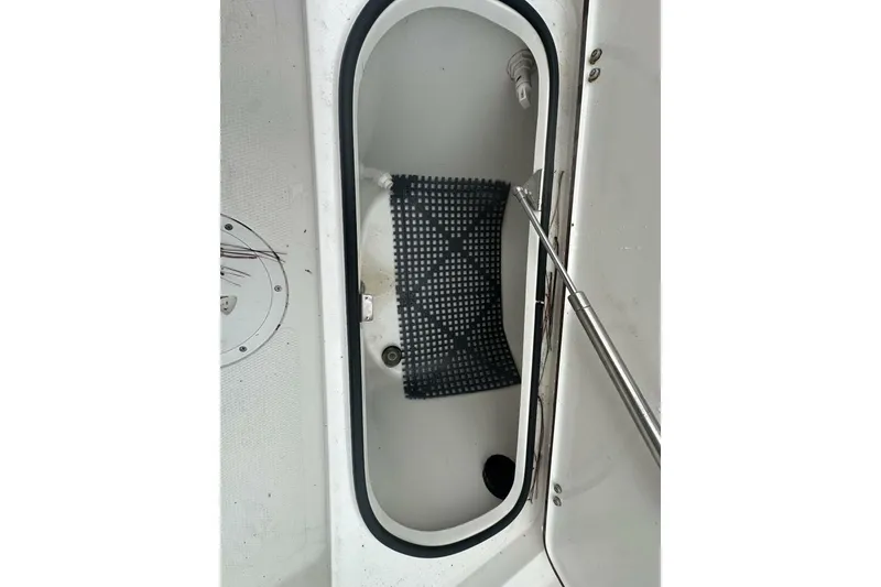 Slide: The Image of Open storage compartment in 2022 BlackJack 256 Bay boat with black mat inside. - 16