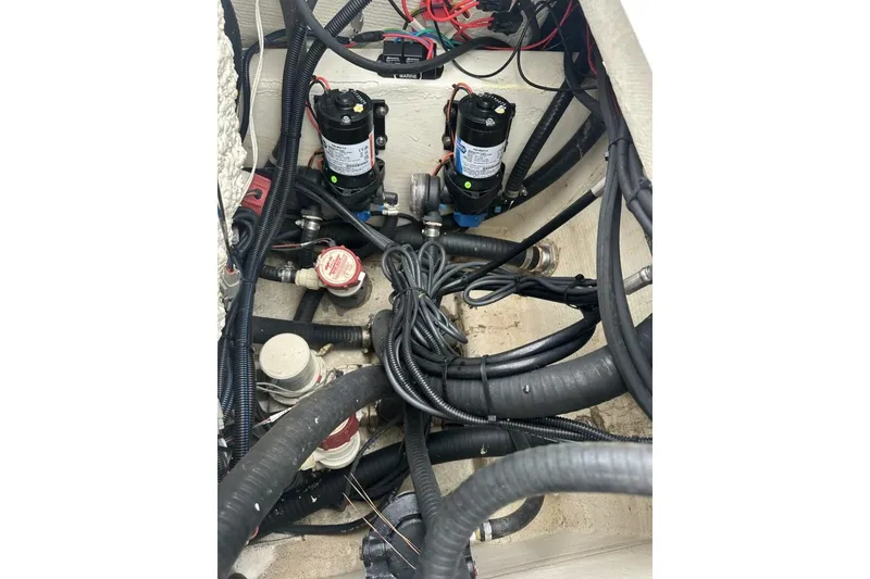 Slide: The Image of 2022 BlackJack 256 Bay boat wiring and pump system in the engine compartment. - 17