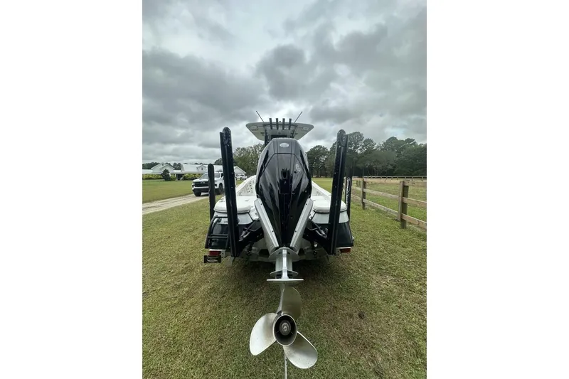 Slide: The Image of 2022 BlackJack 256 Bay boat on grass, rear view with cloudy sky. - 3