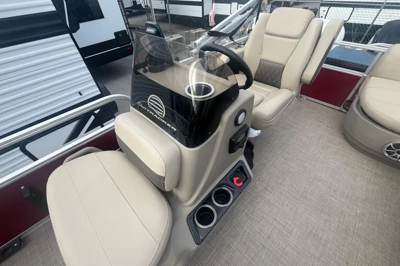 Slide: The Image of 2025 Sun Tracker Bass Buggy 16 XL Select interior with beige seating and steering console. - 13