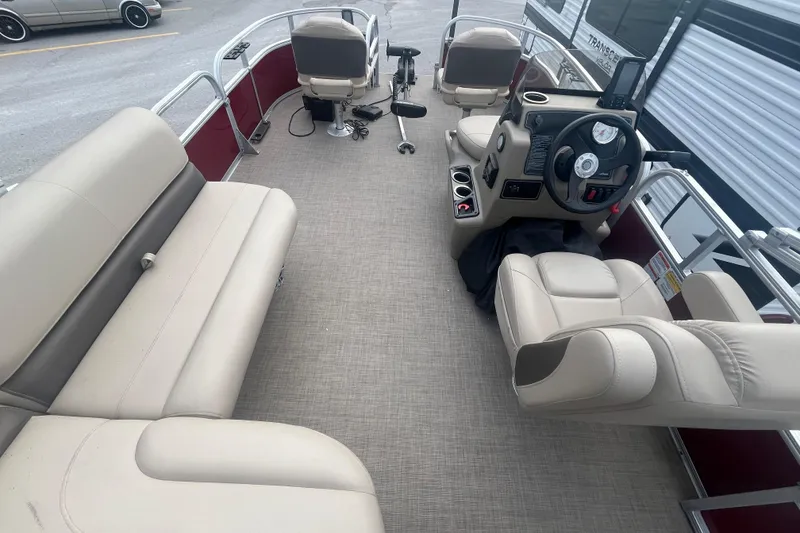 Slide: The Image of 2025 Sun Tracker Bass Buggy 16 XL Select interior with beige seating and steering console. - 17