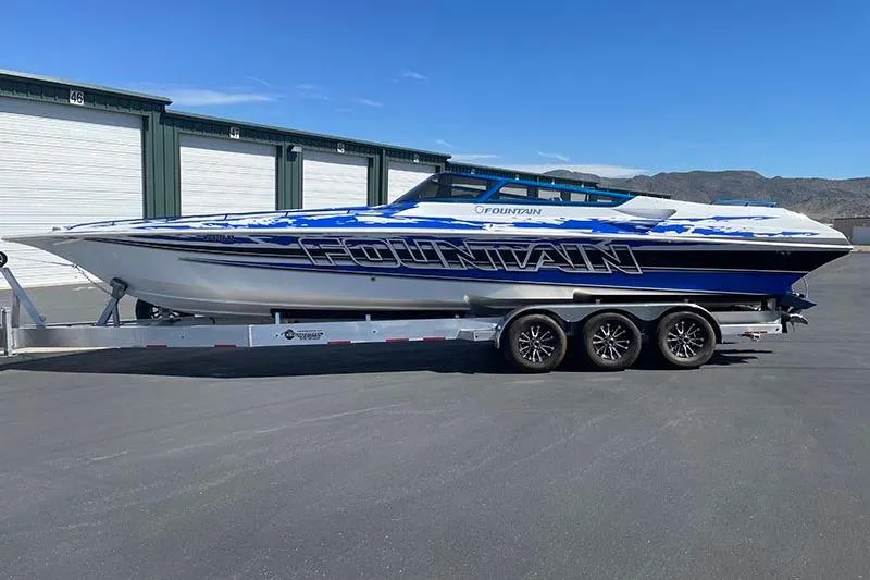 Slide: The Image of 2001 Fountain 35 Lightning speedboat on trailer, parked outdoors, blue and white design. - 4