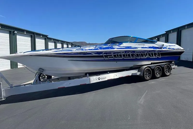 Slide: The Image of 2001 Fountain 35 Lightning speedboat on trailer, parked outdoors, showcasing sleek design. - 5