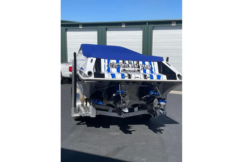 Slide: The Image of 2001 Fountain 35 Lightning boat with blue cover, parked near storage units. - 9