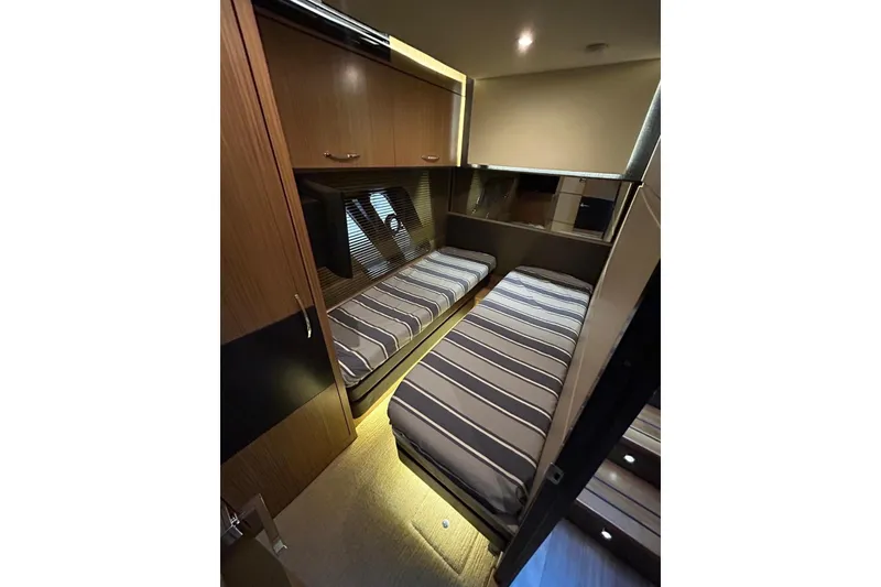 Slide: The Image of 2016 Sea Ray L650 yacht cabin with twin beds and modern wood finish. - 31