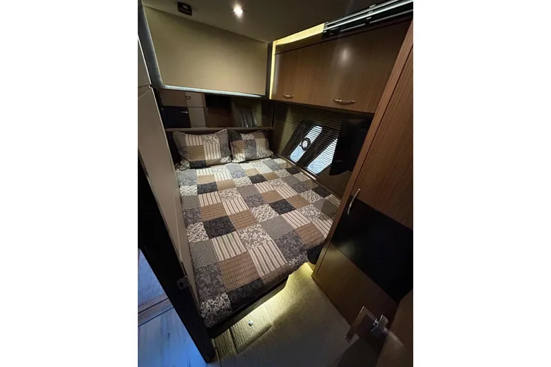 Slide: The Image of Luxurious cabin interior of 2016 Sea Ray L650 yacht with cozy bed and wooden cabinetry. - 33