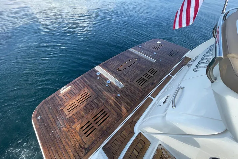 Slide: The Image of 2016 Sea Ray L650 yacht with wooden deck and American flag on calm water. - 46