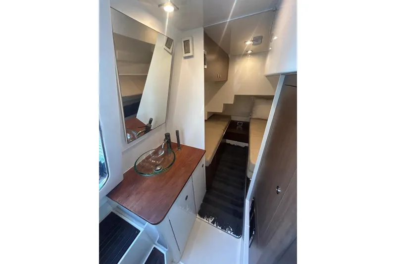 Slide: The Image of 2016 Sea Ray L650 yacht interior with modern bathroom and cozy sleeping area. - 9