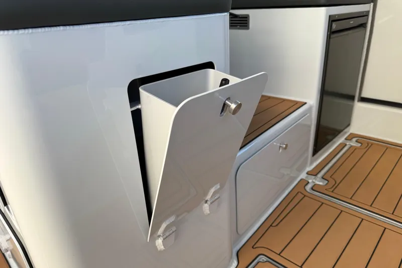 Slide: The Image of Makaira Gen3 26 Outboard 2026 interior with storage compartment and wood-patterned flooring. - 13