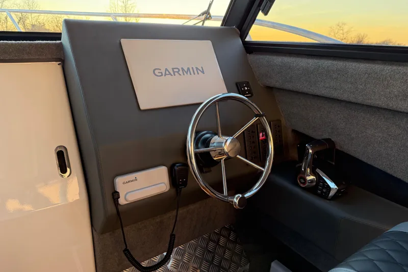 Slide: The Image of Helm of 2026 Makaira Gen3 26 Outboard with Garmin navigation system at sunset. - 18