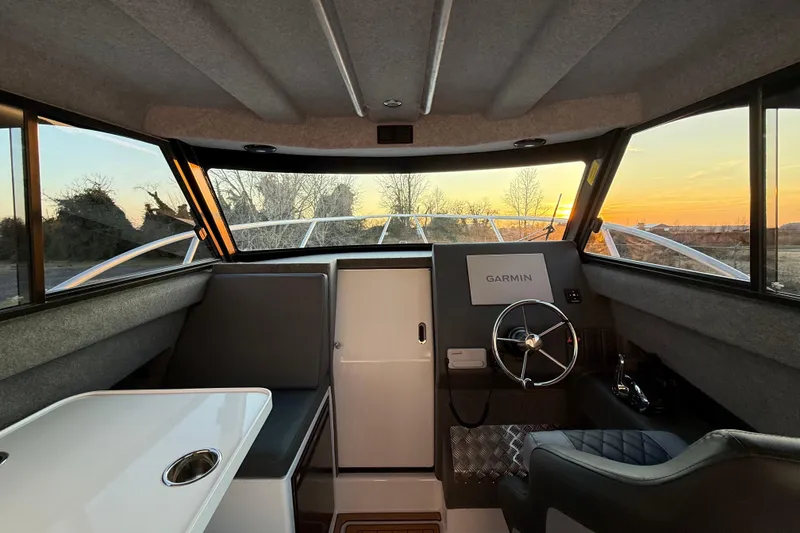 Slide: The Image of Interior of 2026 Makaira Gen3 26 Outboard boat with Garmin navigation system at sunset. - 25