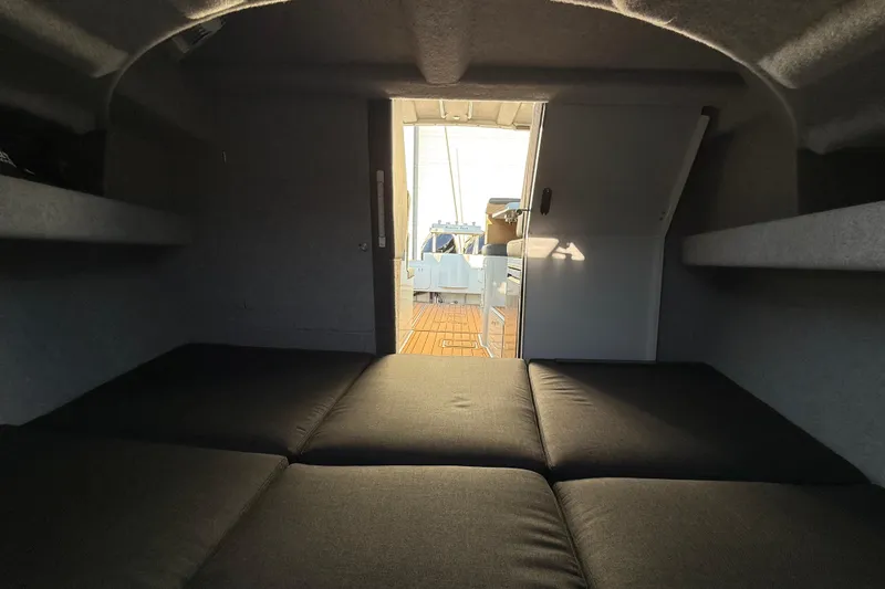 Slide: The Image of Interior cabin view of 2026 Makaira Gen3 26 Outboard boat, featuring cushioned seating. - 30