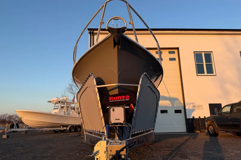 Slide: The Image of 2026 Makaira Gen3 26 Outboard boat on trailer, parked near a building. - 5